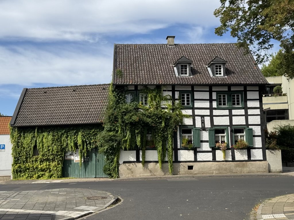 Fachwerkhaus am Lindenplatz in Merzenich bei Sonnenschein, blauem Himmel mit ein paar Schleierwolken davor.