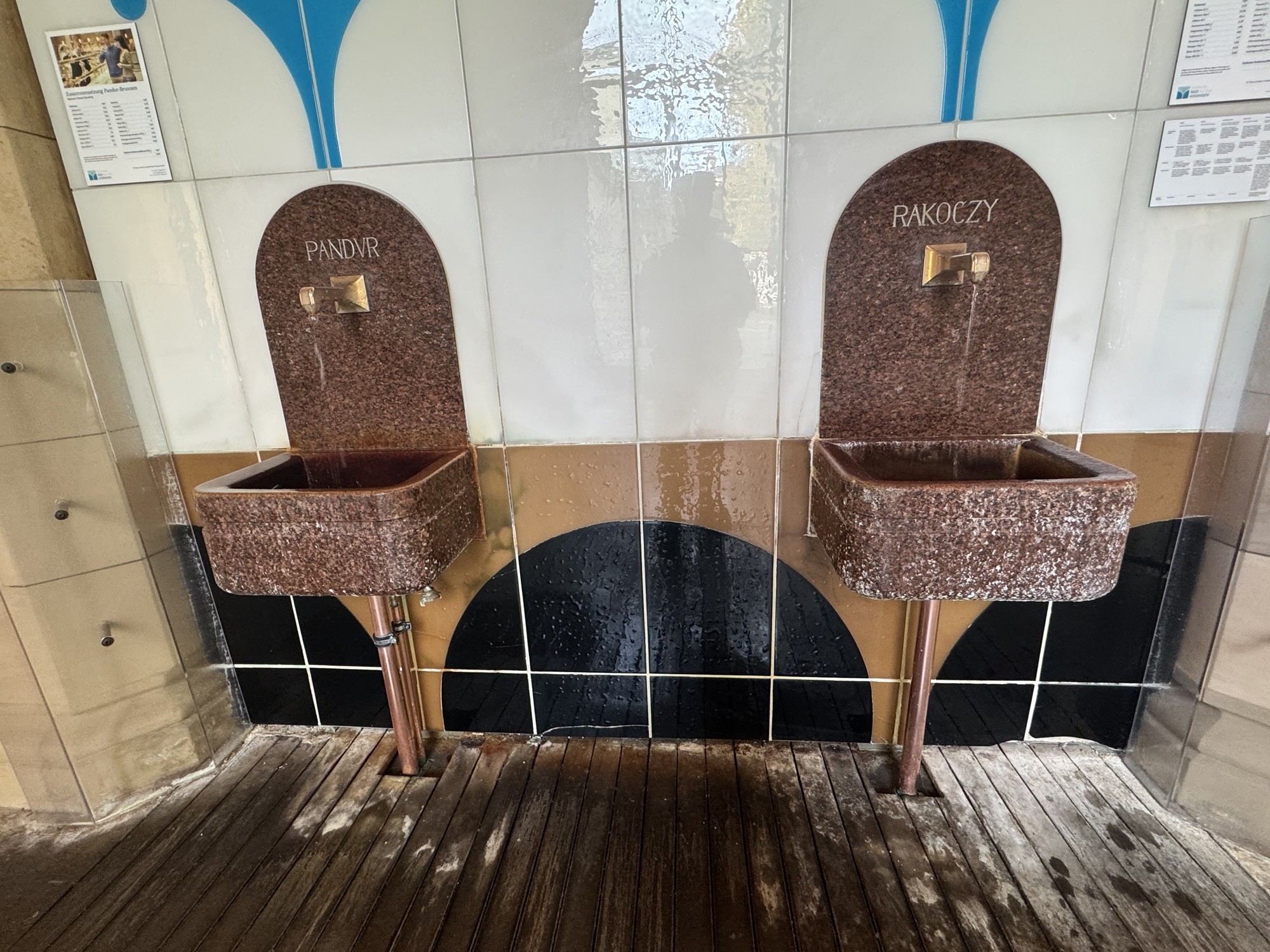 Zwei historische Trinkbrunnen aus rotem Granit mit Messingarmaturen für die Heilquellen Pandur und Rakoczy in der Wandelhalle Bad Kissingen.
